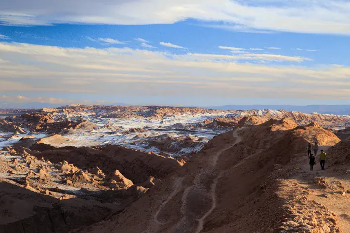 Two travelers walking a ridge above the Atacama’s Valle de la Luna