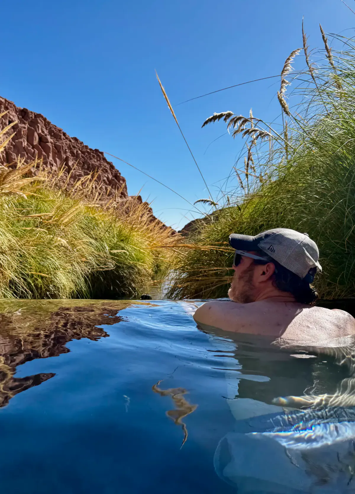 A guest relaxing in a natural hot spring in the Atacama
