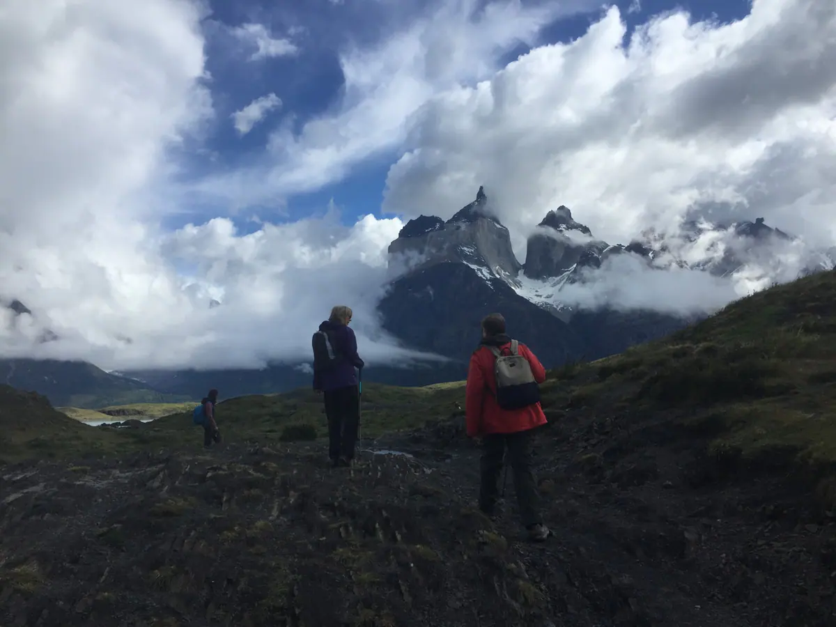 Hikers looking toward the Paine massif under a stormy sky